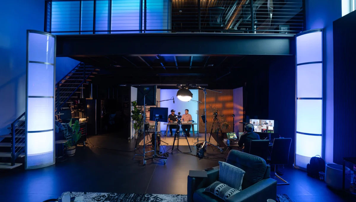 Overhead view of Sanctum Studio production floor in Roanoke TX showing filming setup, lighting rigs, lounge area, and two-story layout